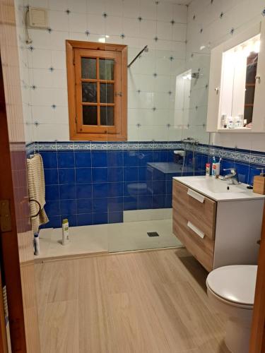 a bathroom with a blue and white tiled wall at Casa con jardin ,vistas al mar y atardecer en Playas de Fornells in Es Mercadal