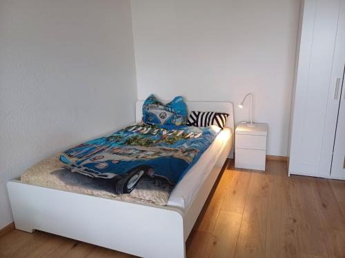 een wit bed met een blauwe deken erop in een kamer bij feel-good-appartements in Karlsruhe
