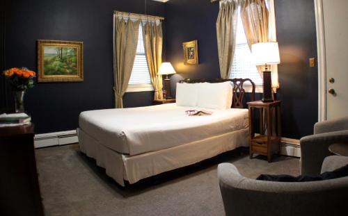 a bedroom with a bed and a chair at Carisbrooke Inn Bed & Breakfast in Ventnor City