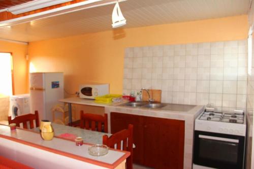 a kitchen with a sink and a stove top oven at Le carambolier maison avec vue imprenable in La Trinité