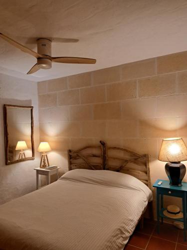 a bedroom with a bed and two tables with lamps at Casa con jardin ,vistas al mar y atardecer en Playas de Fornells in Es Mercadal