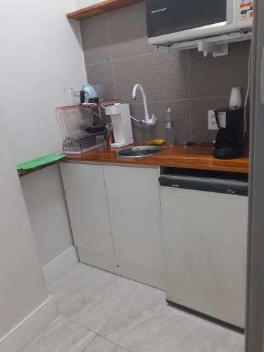 a kitchen with white cabinets and a counter top at Apart Prime in Campinas