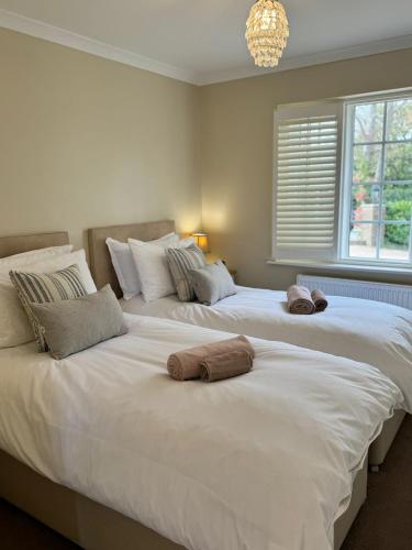 two beds sitting next to each other in a bedroom at Situated in Stunning Highleigh Village,'BRAMLEY FALL COTTAGE'-Attached Cottage,3 Bedrooms-1 on ground level, SLEEPS 6-2 Bathrooms, 9 mins to Sandy Wittering Beach, 5 mins from Southend Barns, Child friendly,Small Breed Dog Friendly 2 max, Parking-EV Point in Chichester