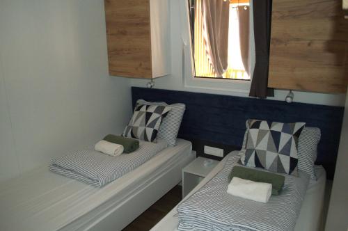 two beds in a room with two windows at Mobile home - EXCLUSIVE in Biograd na Moru