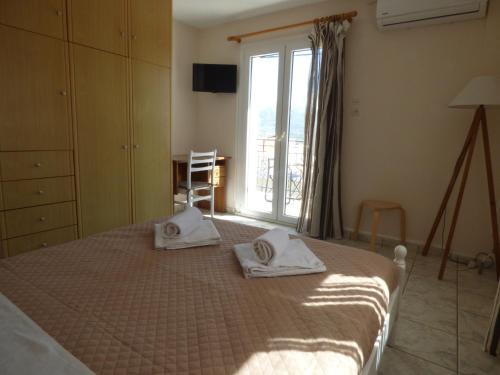 a bedroom with a bed with two towels on it at Anna Apartments in Argostoli