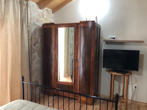 a bedroom with a large wooden cabinet and a television at Covo Residence - Casa Santiago in Vila Nova de Paiva