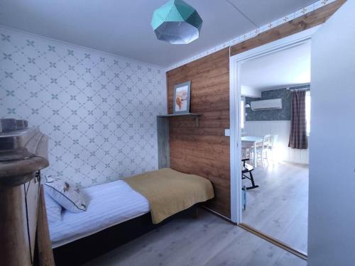 Dormitorio pequeño con cama y espejo en Norwegian house Maria Stua, en Mefjordvær
