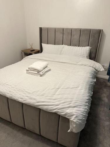 a white bed with two towels on top of it at Lovely Modern One bedroom Flat close to station in Belvedere