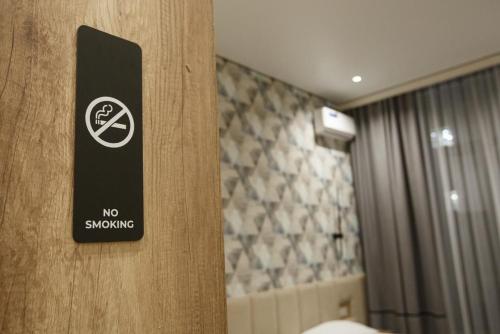 a no smoking sign on a door in a bathroom at ASYL Hotel in Astana