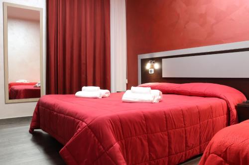 ein rotes Schlafzimmer mit 2 Betten und roten Wänden in der Unterkunft Hotel Paradiso in Falerna