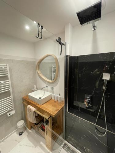 une salle de bain avec un lavabo et un miroir dans l'établissement Maison cosy, 2 chambres, adossée aux remparts, à Aigues-Mortes