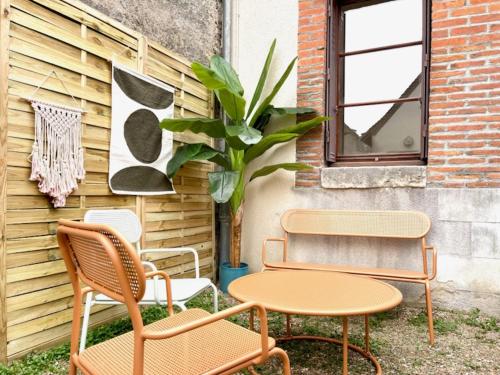 three chairs and a table next to a building at Le Nid Arrivé autonome clim wifi linge inclus in Romorantin