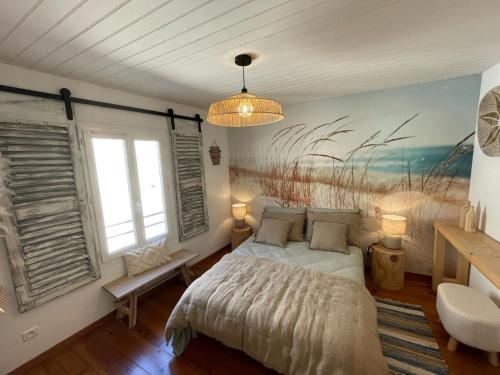 une chambre avec un lit et un tableau au mur dans l'établissement Maison cosy, 2 chambres, adossée aux remparts, à Aigues-Mortes