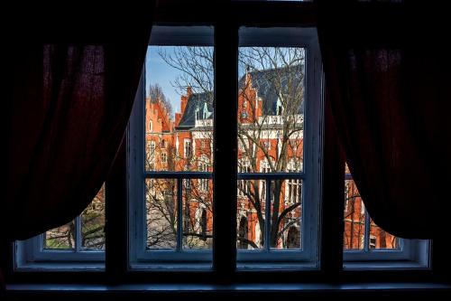 a window with a view of a building at Trzy Kafki Private Rooms in Kraków