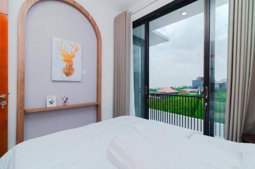 ein Schlafzimmer mit einem weißen Bett und einem großen Fenster in der Unterkunft Villa Ree Private Pool and Balcony in Tlekung