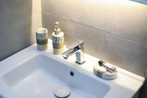 發羅拉的住宿－Guest House Narta，浴室水槽,上面装有水龙头和杯子