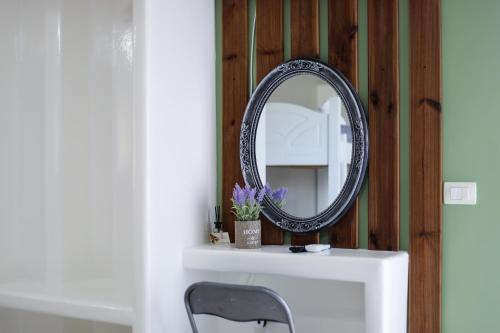 a mirror on top of a white shelf with a chair at Guest House Narta in Vlorë