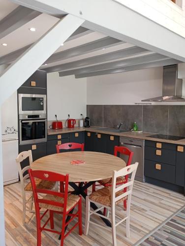 une cuisine avec une table et des chaises en bois dans l'établissement Le gîte du Galou, à Sully