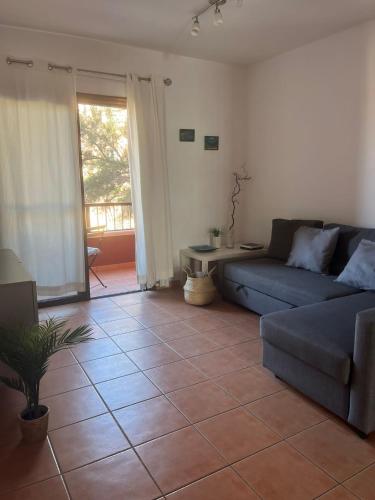 a living room with a couch and a tile floor at Apartamento en El Médano con piscina y garaje in El Médano