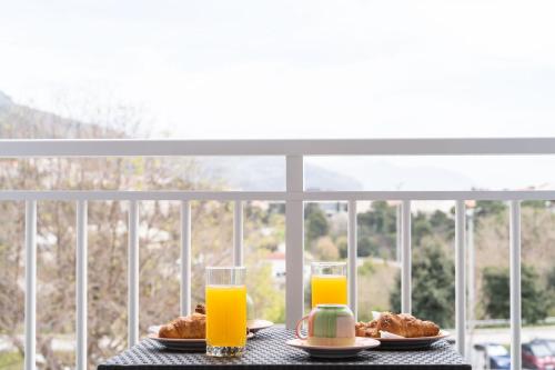 a table with two plates of food and two glasses of orange juice at Star Apartments Dubrovnik in Dubrovnik