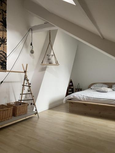 - une chambre mansardée avec un lit et une échelle dans l'établissement L Ecume, à Saint-Valery-en-Caux