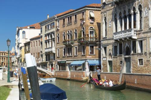 a man on a boat in the middle of a river at Palazzo Guardi in Venice