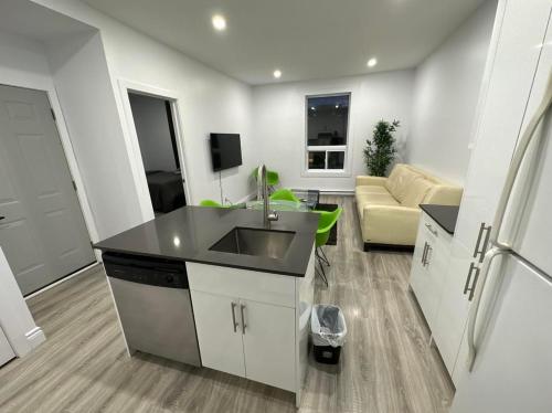 uma cozinha com um lavatório e uma sala de estar em Appartement 2 chambres - 202 em Montreal