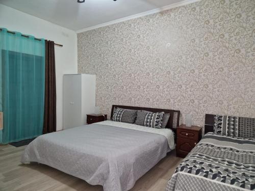 a bedroom with two beds and a wall at Milner Flats in Sliema