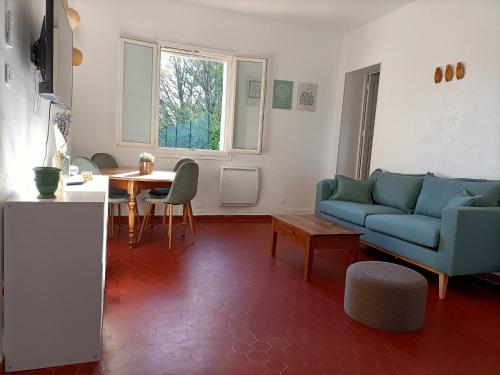 un salon avec un canapé bleu et une table dans l'établissement LA BASTIDE D'AIX, à Aix-en-Provence