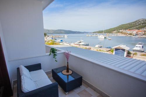 uma varanda com um sofá e vista para um porto em Villa Samac em Trogir