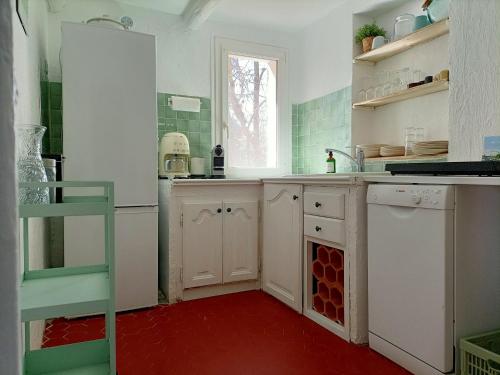 - une cuisine avec des placards blancs et un sol rouge dans l'établissement LA BASTIDE D'AIX, à Aix-en-Provence