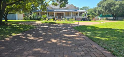 a brick path in front of a house at Grey lourie Guesthouse in Zeerust