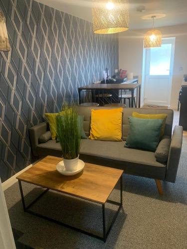 a living room with a couch and a table at Cozy Diamond Apartment in Bletchingdon