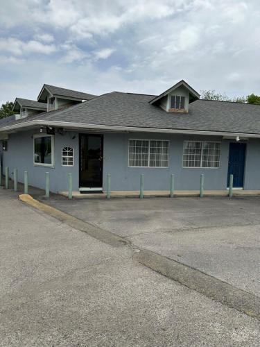 a blue house with a parking lot in front of it at Sands Motel in San Antonio