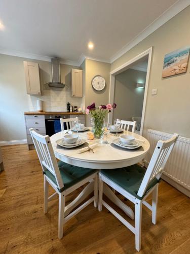 a kitchen with a table with chairs and a dining room at 'BRAMLEY FALL COTTAGE', CHILD FRIENDLY, 3 Separate Bedrooms -1 on ground level, SLEEPS 6, 2Bathrooms, Wittering Beach 8min drive, Rural Location, Private Parking in Chichester