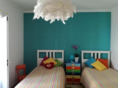 um quarto com 2 camas e uma parede azul em Casa Bambu, Paraiso na Terra em Praia Verde