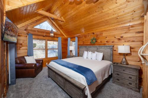 ein Schlafzimmer mit einem Bett und einem Stuhl in einer Hütte in der Unterkunft Unto These Hills in Sevierville