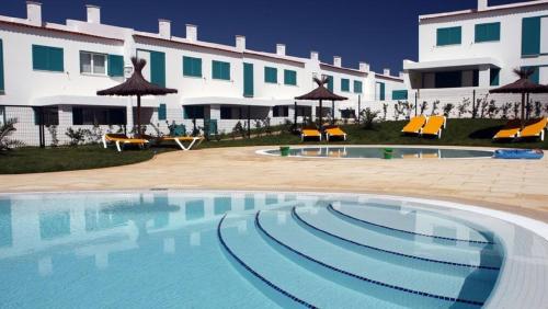 a large swimming pool in front of a building at ALVOR VILLAGE BY THE SEA in Alvor