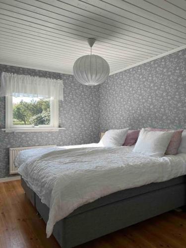 a bedroom with a large bed with a ceiling at Stuga i Björkäng med havsutsikt! in Tvååker