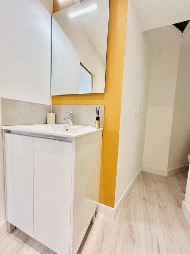 une salle de bain avec un lavabo et un miroir dans l'établissement Bienvenue dans notre petit havre de paix !, à Boulogne-sur-Mer