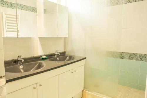 a bathroom with a sink and a shower at Appartement standing avec 2 chambres et balcon in Boulogne-Billancourt