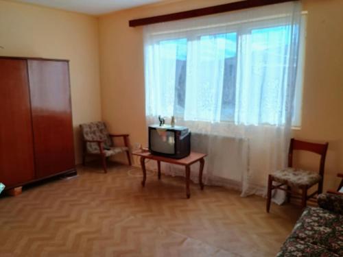 a living room with a tv on a table and a window at Vila Codrin in Iaşi