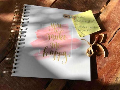 a spiral notebook with a note and a flower at Light flow stylish attic house. m. balcony in Rastatt