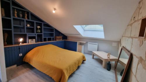 a attic bedroom with a bed and a skylight at Duplex cosy dans la rue des caves à vin in Saumur