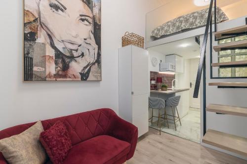 a living room with a red couch and a kitchen at CASA GIULIA BUDAPEST in Budapest