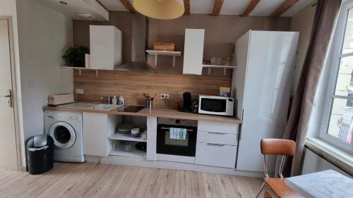 a kitchen with a refrigerator and a sink and a microwave at Duplex cosy dans la rue des caves à vin in Saumur