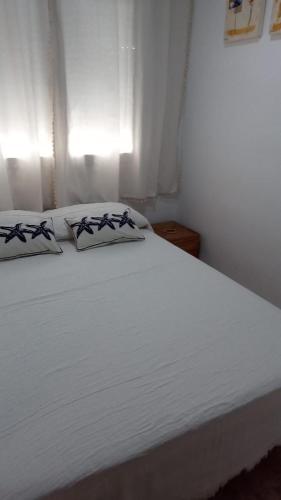 a white bed with two pillows on top of it at Arel in Riumar