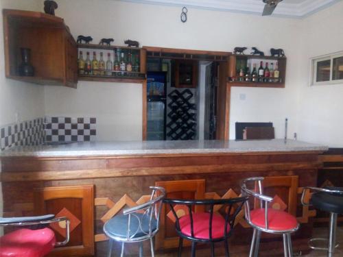 un bar con sillas rojas y azules en una habitación en Legends Castle Suites, en Gwarinpa