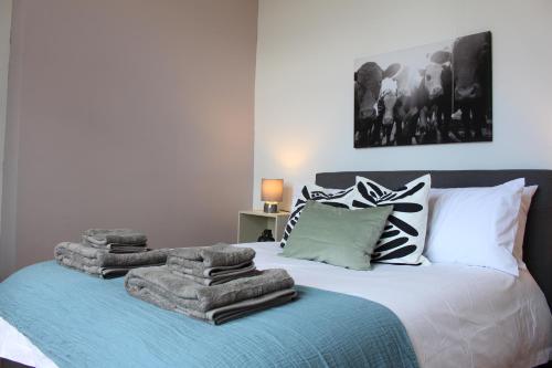 een slaapkamer met een bed met handdoeken erop bij Flat 5, Westhill in Leeds