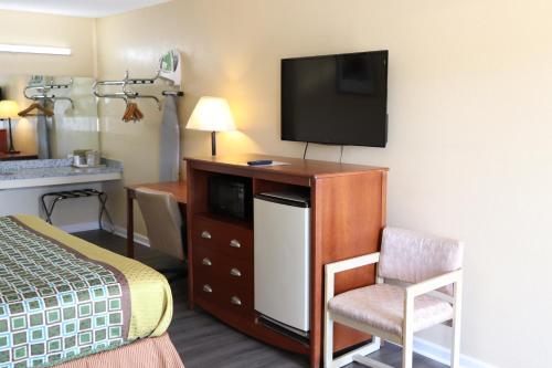 een hotelkamer met een bed en een flatscreen-tv bij Woodstream Inn in Hogansville
